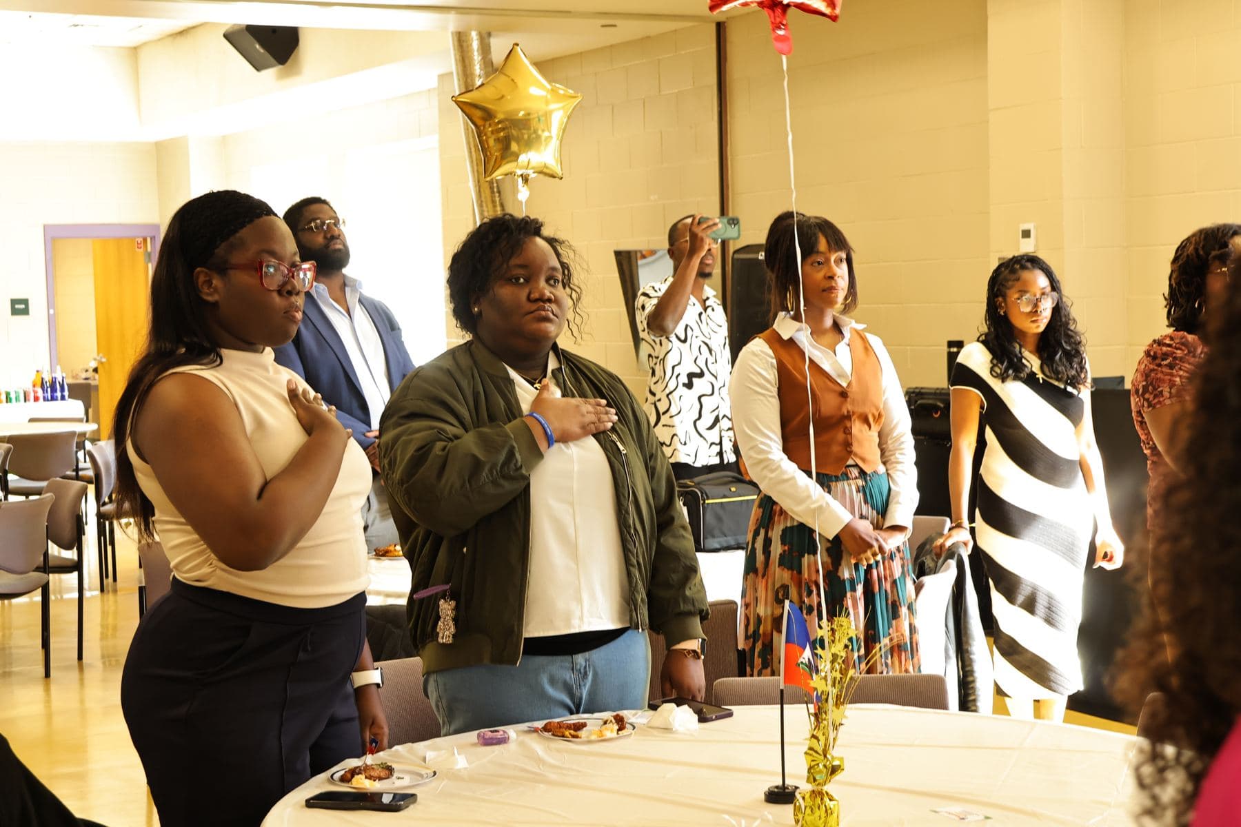 Guests standing with hands over their hearts