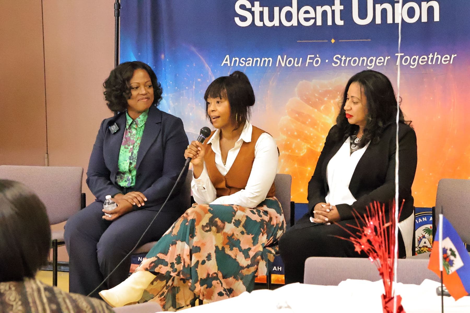 Panelists seated in front of the MAHSU banner, one speaking into a microphone