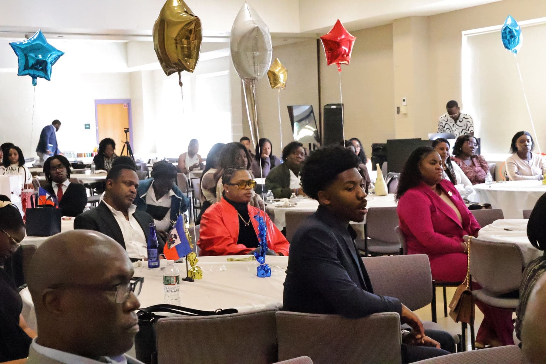 A room full of students and guests seated at round tables