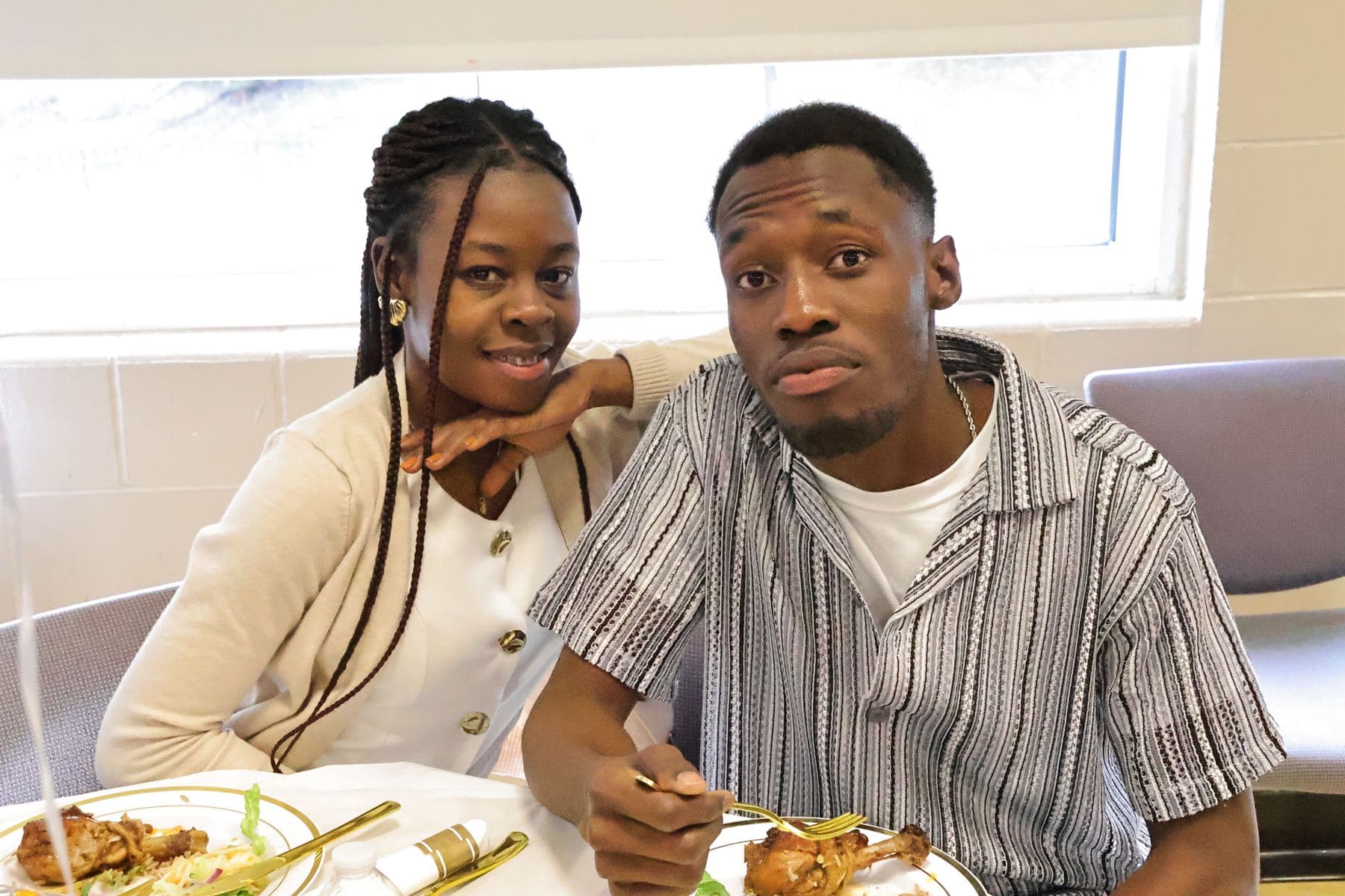 Two students smiling at a dinner table